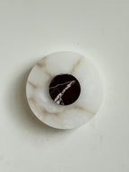 The Clérachic wall lamp from above, honey-veined alabaster carrying a burgundy marble disc split by a single white vein.