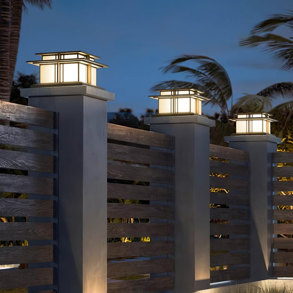 Clérachic Ray pillar lights glowing on posts along a slatted timber fence at twilight.