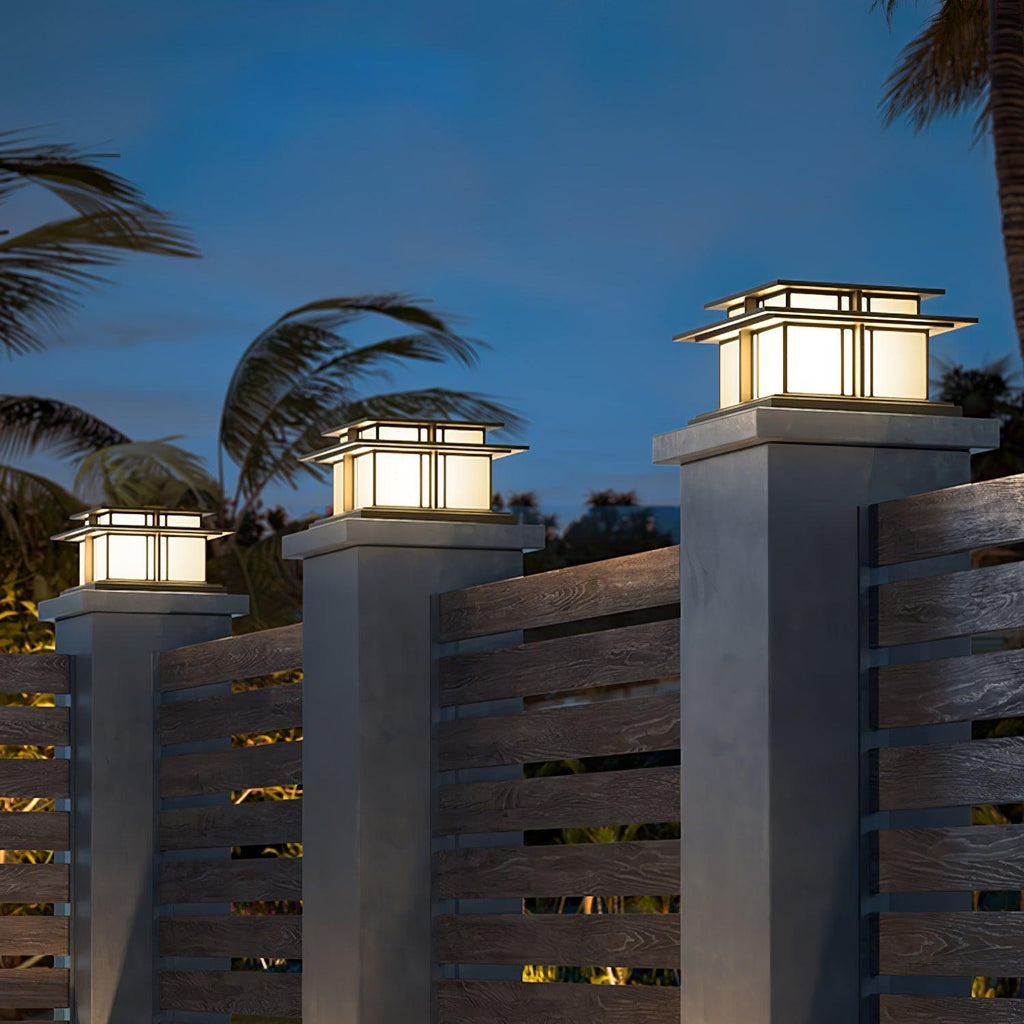 Clérachic Ray pillar lights glowing on posts against a dusk sky with palms behind.