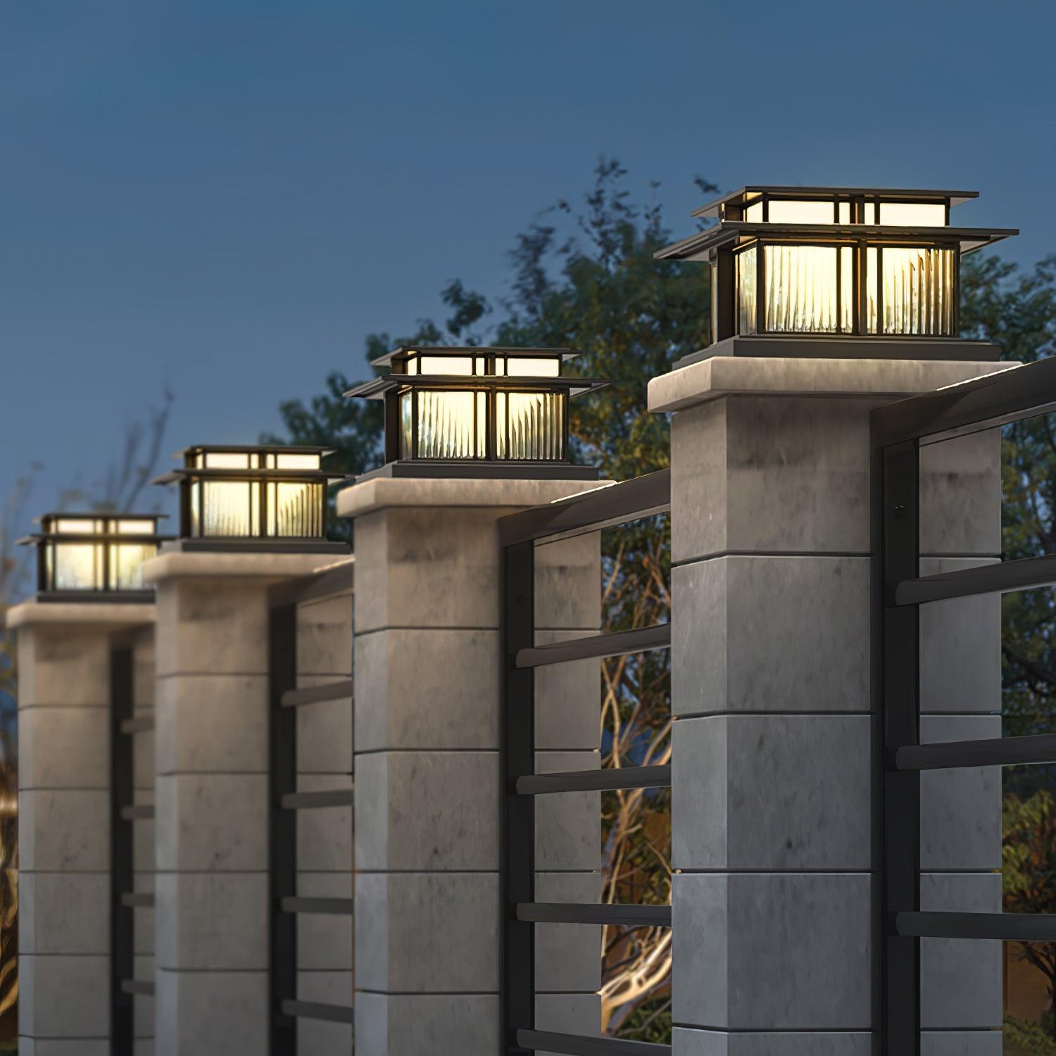 A run of Clérachic Ray pillar lights lit along a concrete and steel boundary fence.