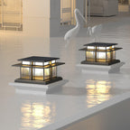 Two Clérachic Ray pillar lights lit at a poolside terrace, reflections across the water.