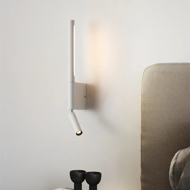 Clérachic slim white wall light with a glowing vertical strip and small reading spot beside a linen headboard and bedside bowls.