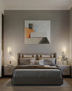 Pair of Clérachic slim white wall lights with reading spots flanking a grey upholstered bed beneath an abstract painting.
