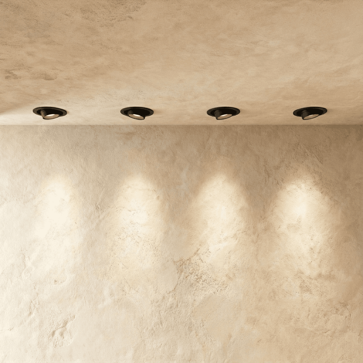 Clérachic black recessed tilting downlights in a limewash ceiling, angled to throw soft pools of light onto the wall.