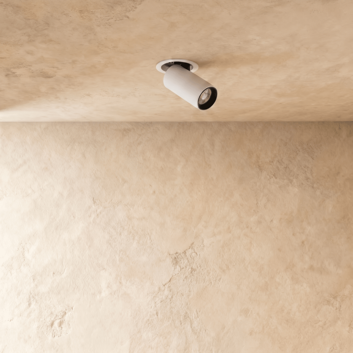 Clérachic white recessed downlight with a black-lined cylindrical head pivoted from a round flush trim on a textured plaster ceiling.