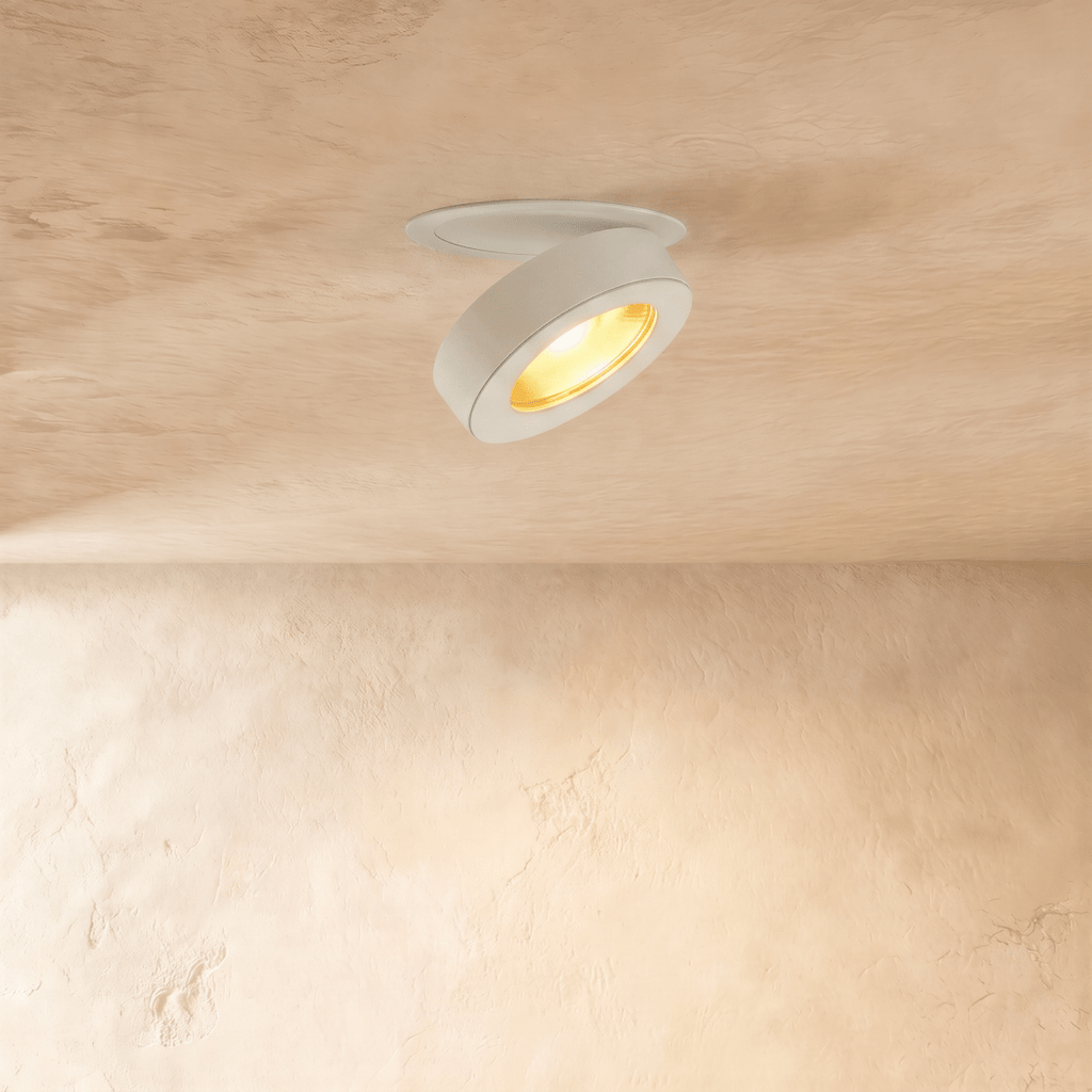 Clérachic recessed downlight in white, head swung open and lit warm on a soft plaster ceiling.