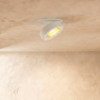 Clérachic recessed downlight in white, head swung open and lit warm on a soft plaster ceiling.