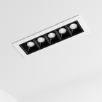 Clérachic recessed five-head linear downlight in a white trim with black square reflectors, set flush into a white ceiling.