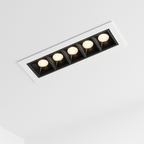 Clérachic five-head recessed linear downlight, lit with warm light from each square black reflector in a white ceiling trim.