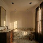 Clérachic square black recessed downlights set in a cream ceiling above a marble bath, shown switched off in daylight.