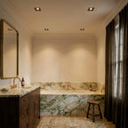 Clérachic square black recessed downlights lit warm in a cream bathroom ceiling above a marble bath and walnut vanity.