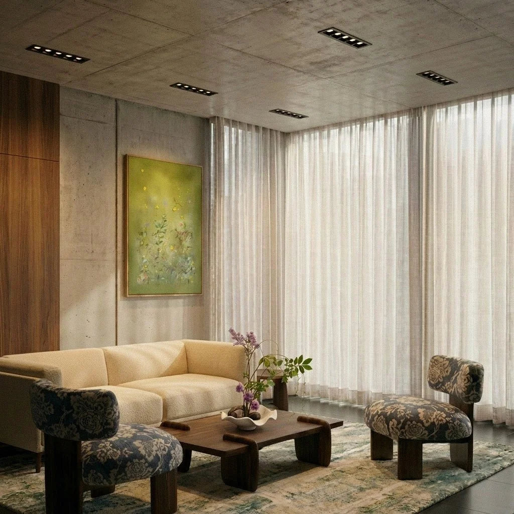 Clérachic black linear recessed downlights spaced across a concrete ceiling above a cream sofa and sheer curtains.