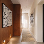 Clérachic recessed step lights set low along a hallway wall, warm glow guiding the walnut-panelled corridor floor.