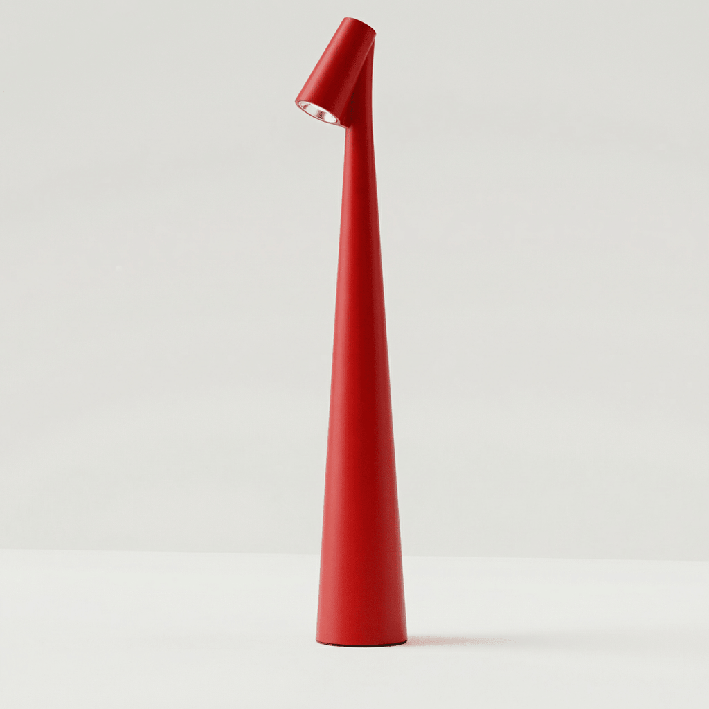 Clérachic cone desk lamp in red, its angled head throwing a small pool of light downward.