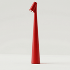 Clérachic cone desk lamp in red, its angled head throwing a small pool of light downward.