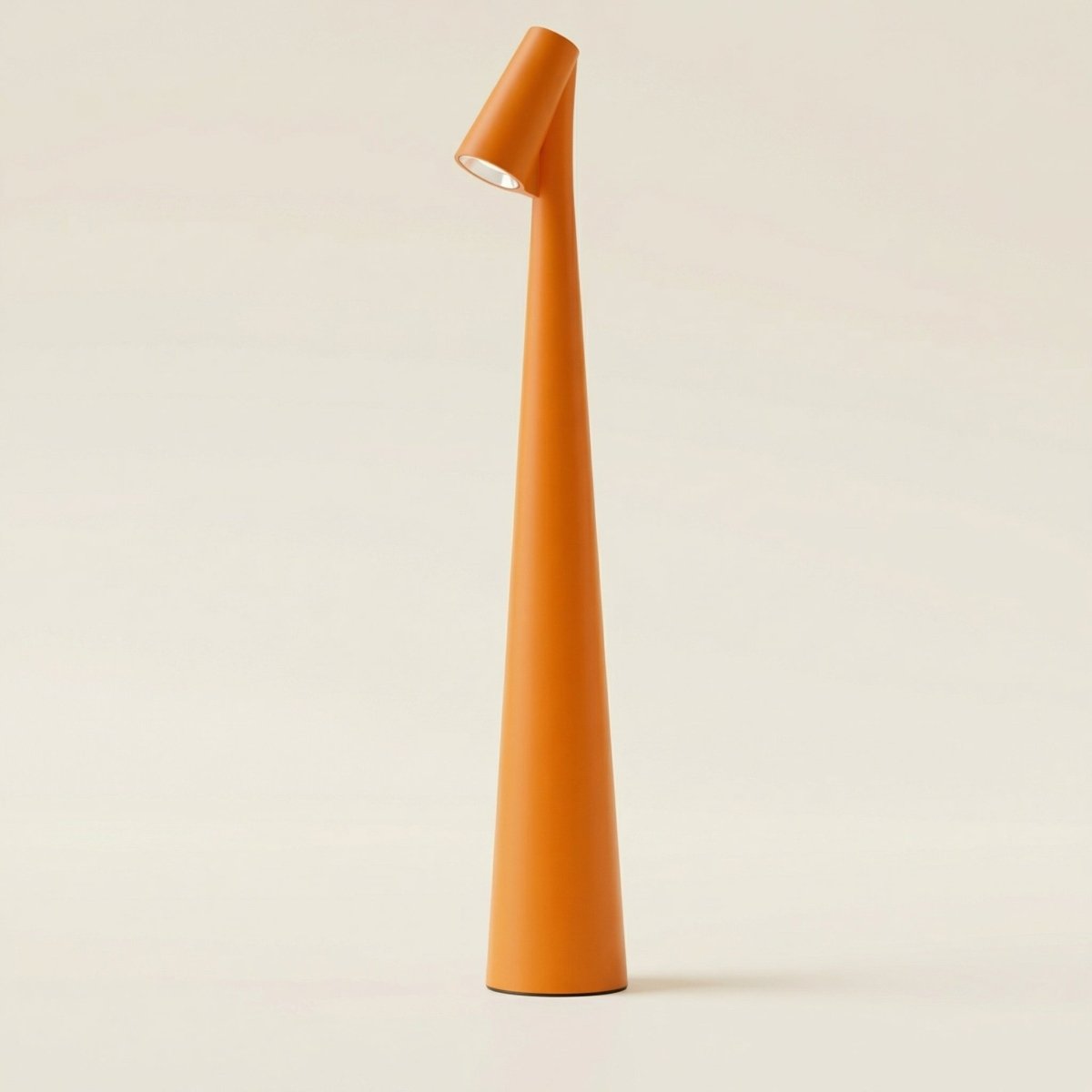 The Clérachic cone desk lamp in orange, photographed against a warm cream backdrop.