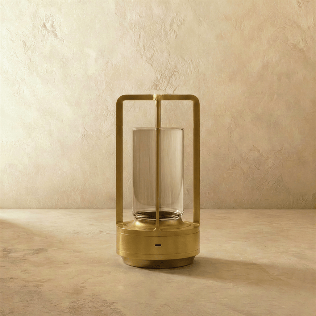 Clérachic brass table lamp switched off, showing the slim open frame, clear glass cylinder and round base with a charging port.