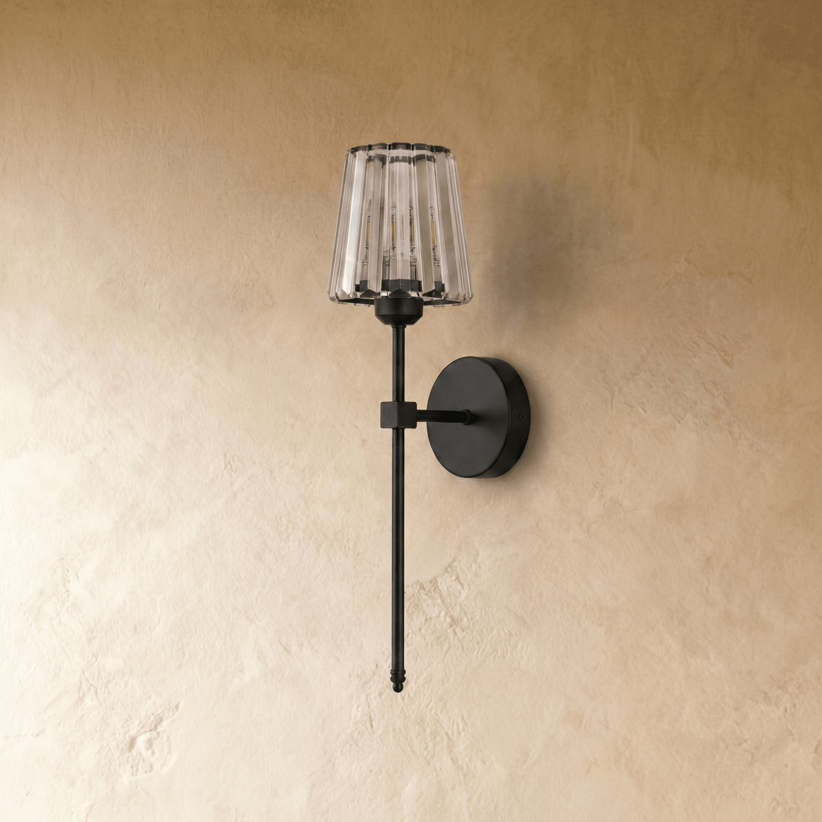 Clérachic black wall sconce with a fluted clear glass shade, switched off, on a round backplate against a plaster wall.