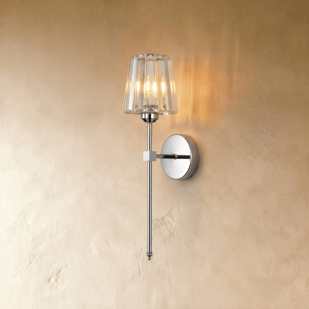 Clérachic polished silver wall sconce with a fluted clear glass shade on a slim rod, lit warm on a limewash wall.