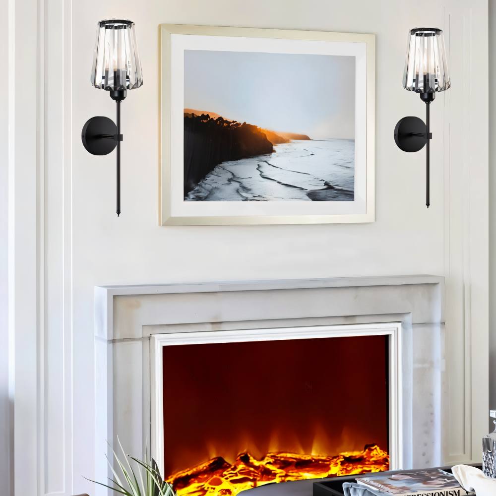 Clérachic pair of black wall sconces with glass shades either side of a framed coastal print above a fireplace.
