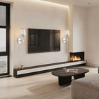 Clérachic pair of silver wall sconces with fluted glass shades either side of a wall-mounted TV in a modern living room.