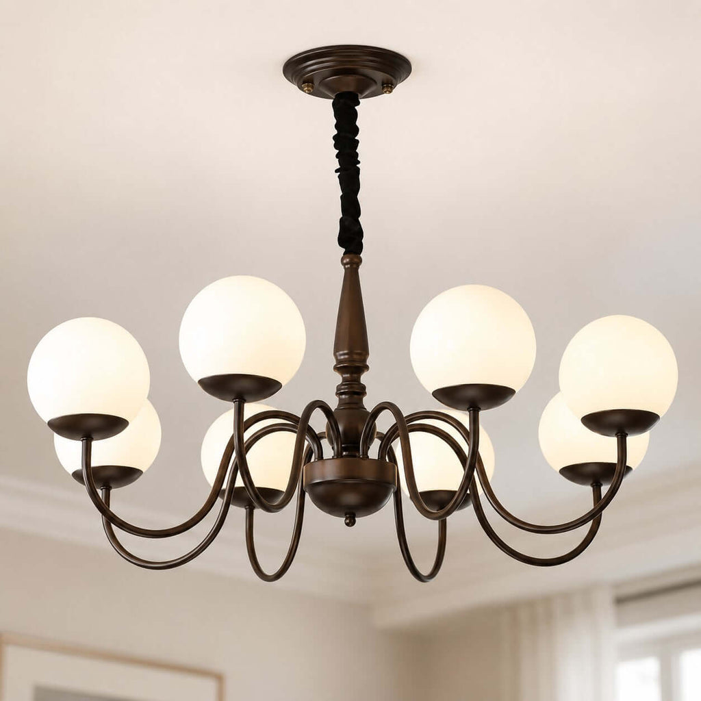Close view of the eight white globes, curved dark bronze arms and turned stem on this Clérachic chandelier, from below.