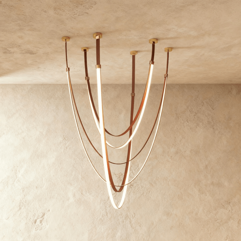 Clérachic leather chandelier, cognac leather straps looping in glowing swags from six brass ceiling mounts.
