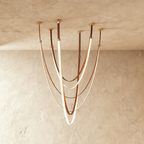 Clérachic leather chandelier, cognac leather straps looping in glowing swags from six brass ceiling mounts.