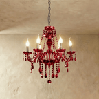 Clérachic deep red crystal chandelier with six candle-style lights, curved arms and faceted drops, hung on a chain.