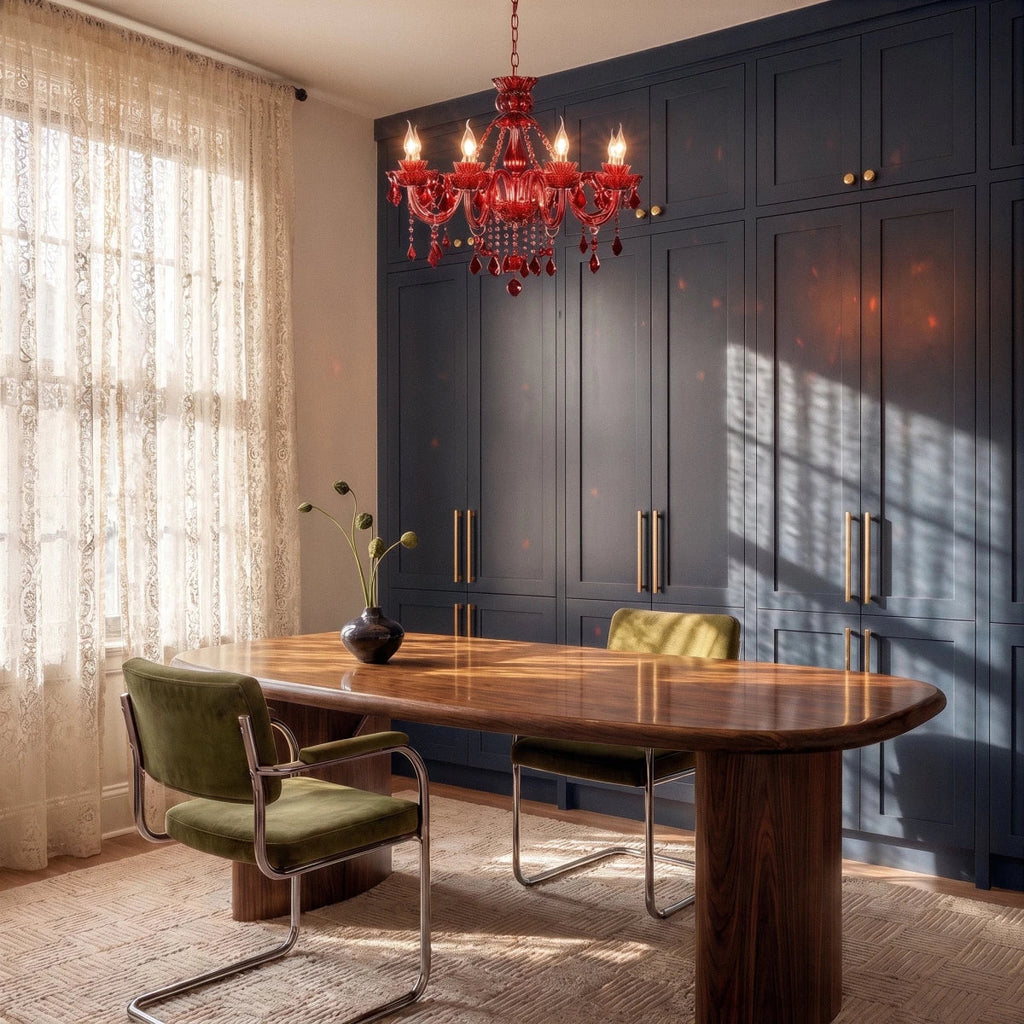 Clérachic red crystal chandelier lit above a walnut dining table with green velvet chairs and a navy built-in cabinet.