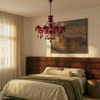 Clérachic red crystal chandelier hanging in a bedroom with a corduroy headboard, a landscape painting and sheer curtains.
