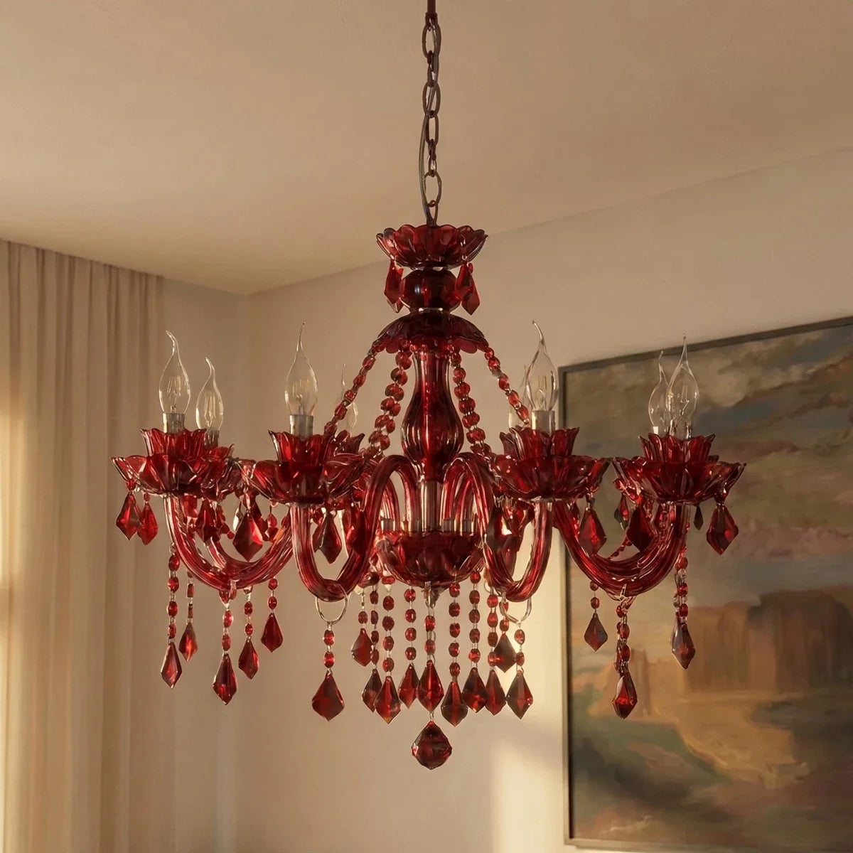 Clérachic red crystal chandelier with candle-style lights in a softly lit room beside cream curtains and a painting.