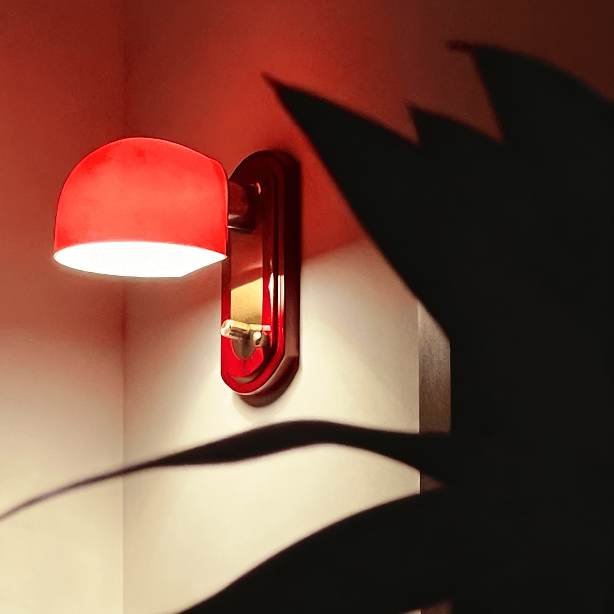 Lit dome of this Clérachic wall light glowing bright red, with the shadow of a large plant leaf falling across the wall.