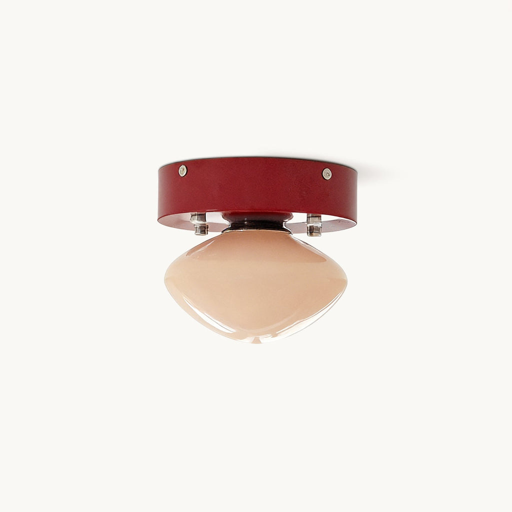 Clérachic flush mount ceiling light with a red iron canopy, silver-toned studs and a smooth beige glass dome, on a plain white backdrop.