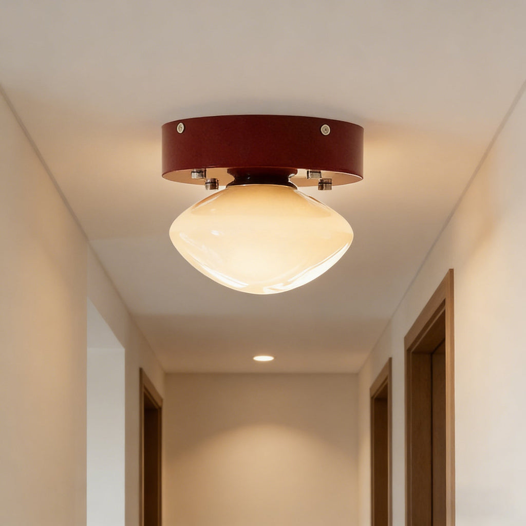 Clérachic red flush mount with a beige glass dome lit above a hallway, with pale walls and timber door frames beyond.