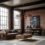 Red ring Clérachic chandelier hung in a brick loft with tall steel windows, above a leather sofa and a reclaimed-wood coffee table.