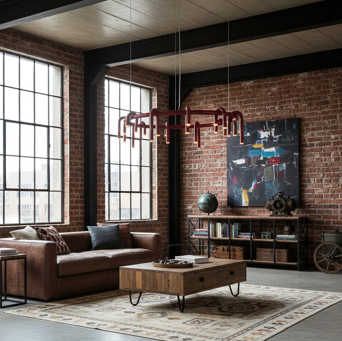 Red ring Clérachic chandelier hung in a brick loft with tall steel windows, above a leather sofa and a reclaimed-wood coffee table.
