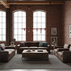 A slim row of red heads from a linear Clérachic chandelier, hung between arched windows above a leather seating area.
