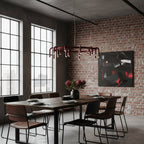 This Clérachic ring chandelier hangs over a dark dining table in an industrial room with brick walls and black window frames.