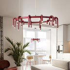 A Clérachic ring chandelier in red in a bright kitchen-and-lounge space, with a second one visible beyond the window.
