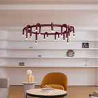 Red Clérachic ring chandelier in front of open white shelves, above an ochre armchair and a round marble table.