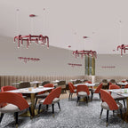 Several red Clérachic chandeliers, ring and linear, hang through a restaurant dining room with coral chairs and terrazzo flooring.