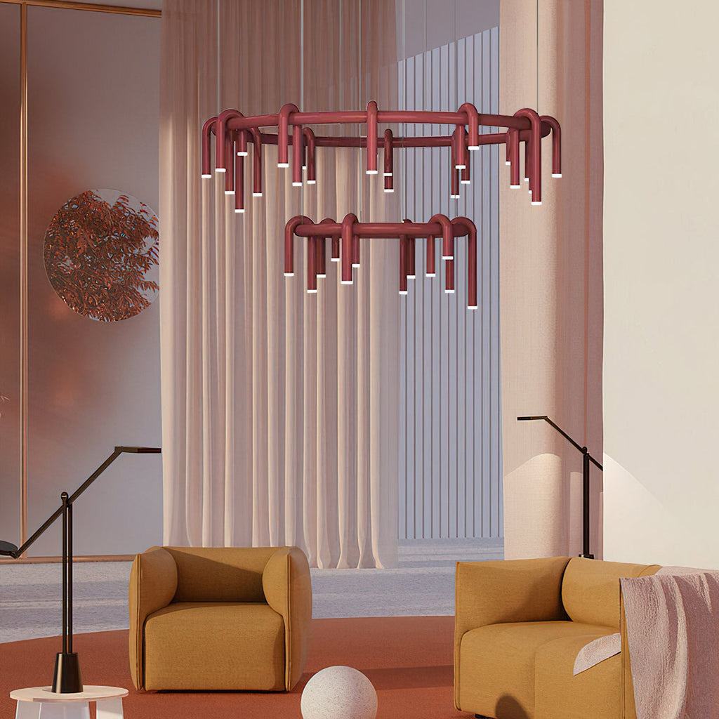 Two red Clérachic ring chandeliers hung one below the other in a curtained room with mustard armchairs and floor lamps.