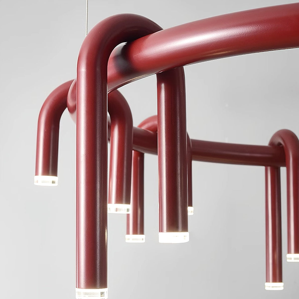 Close view of the red ring and arched tubes on this Clérachic chandelier, with frosted light caps at each tip.