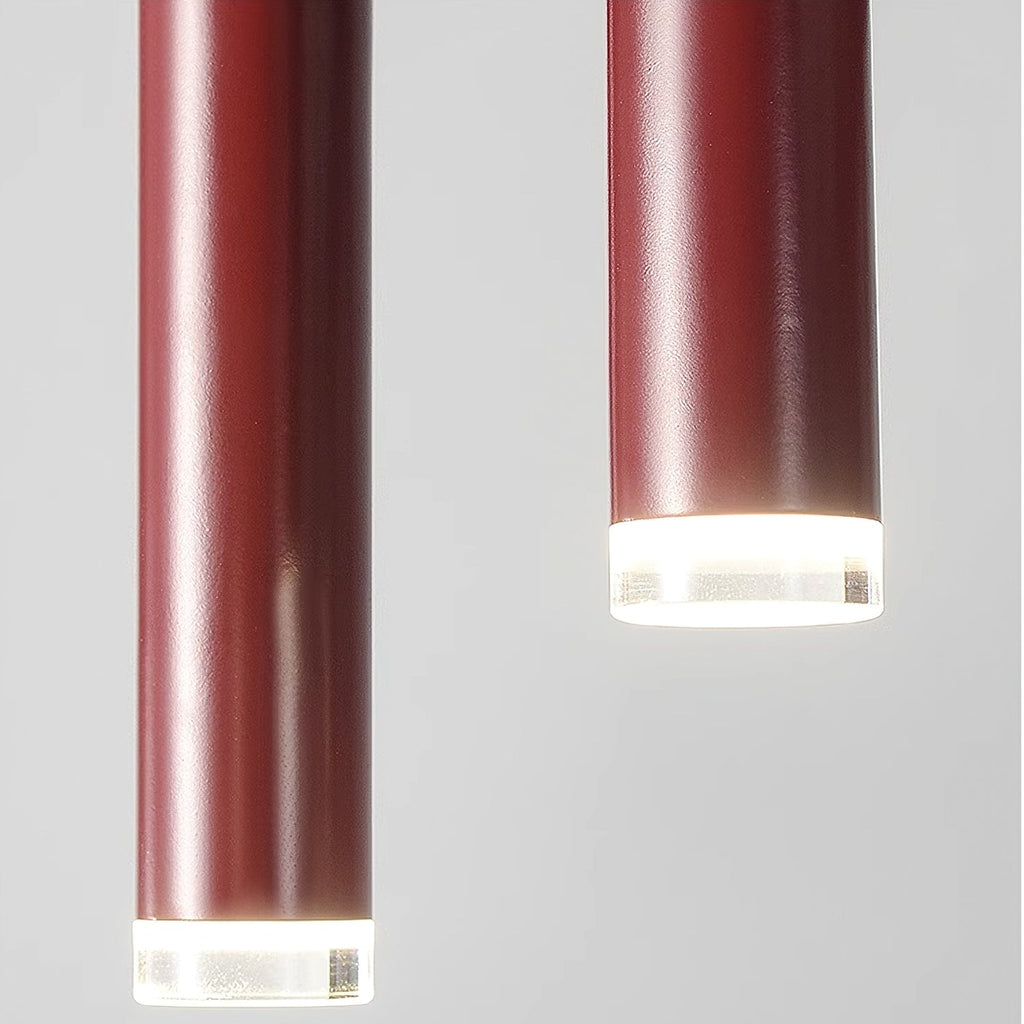Close view of two slim red tubes on this Clérachic chandelier, each with a frosted light cap at the bottom.
