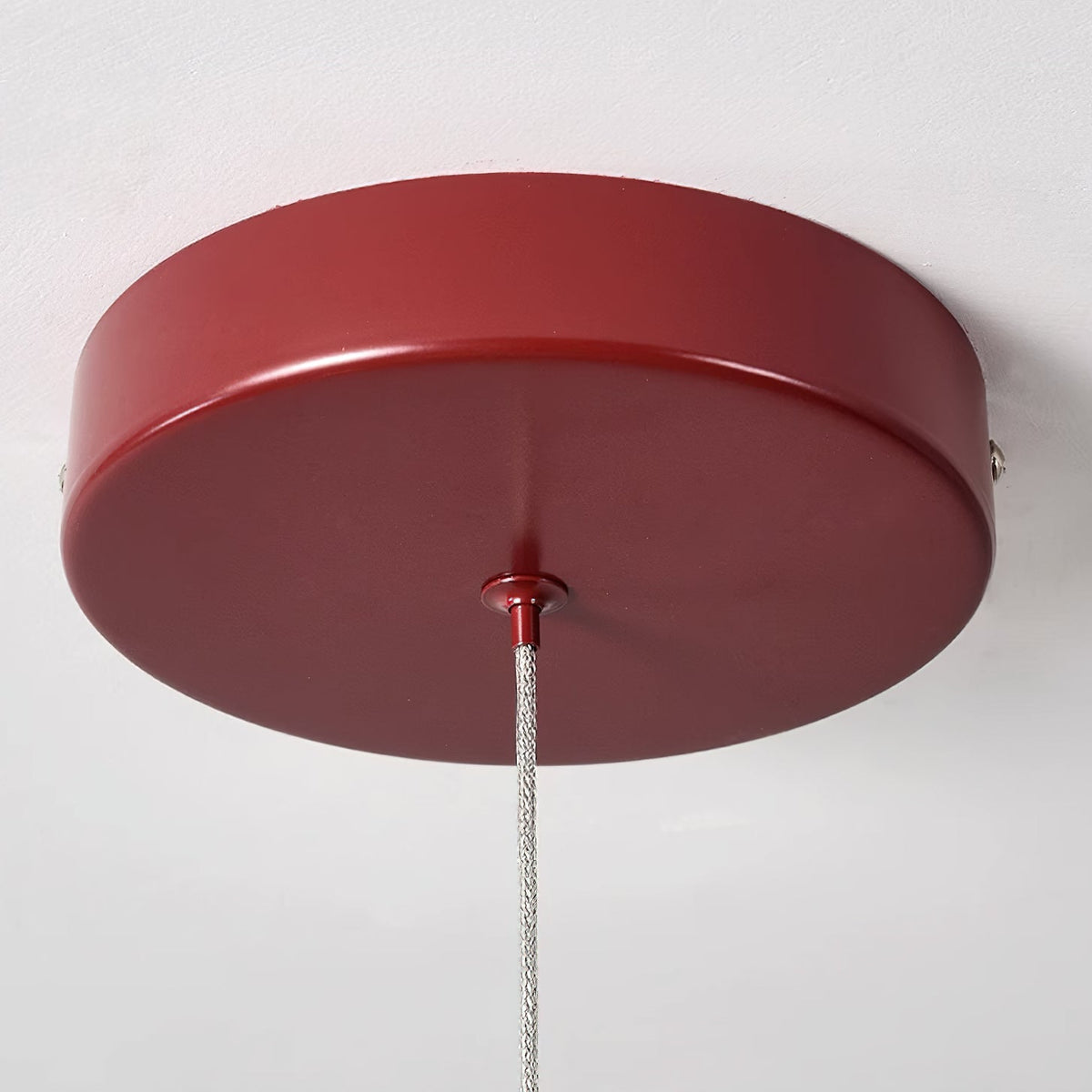 Round red ceiling canopy of this Clérachic chandelier, with a braided cable dropping from the centre.