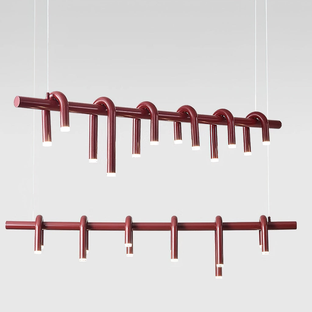 Two views of the linear red chandelier from Clérachic, one angled and one straight, with slim heads on a red bar.