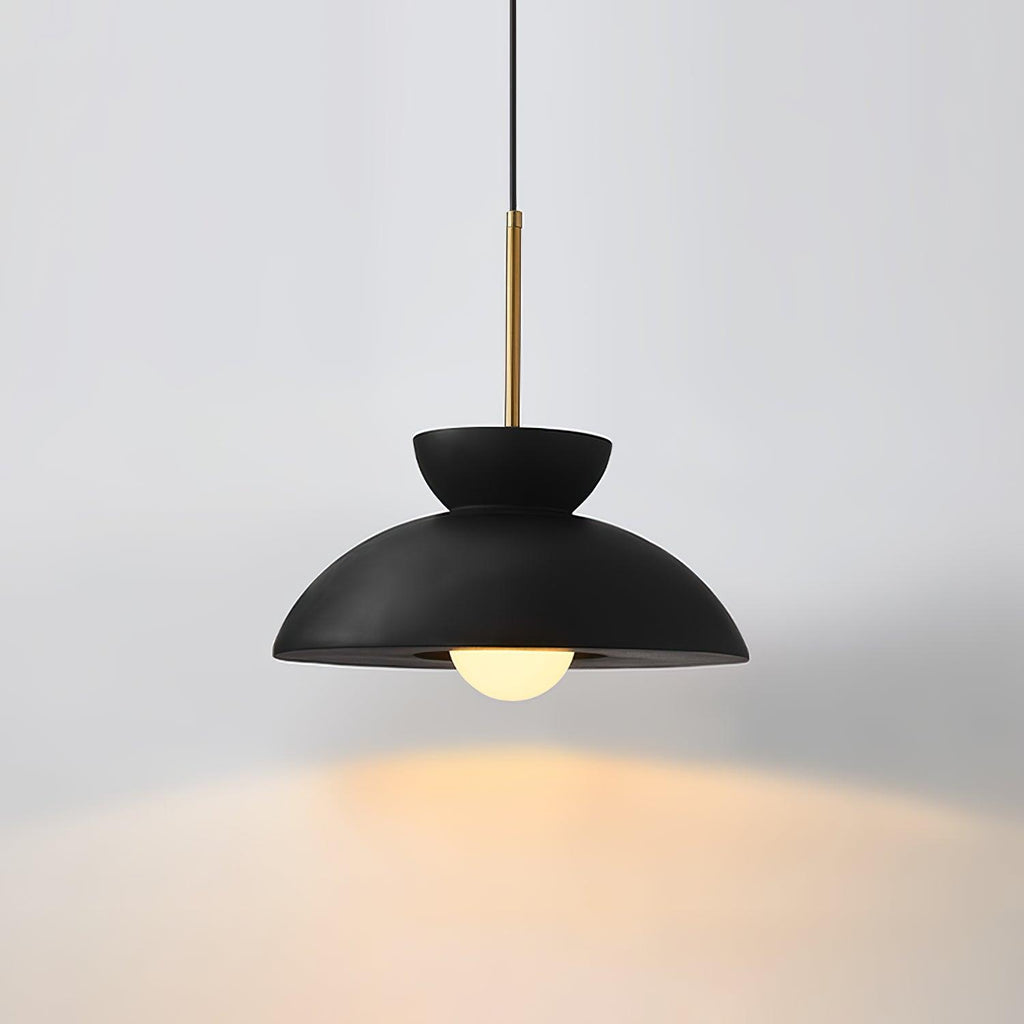 Black Clérachic pendant on a pale grey backdrop, its bulb throwing a warm pool of light onto the surface beneath.