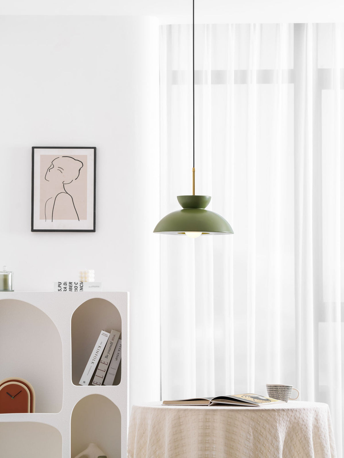 Smaller in frame, this green Clérachic pendant hangs beside a line-drawing print and an arched shelf unit.