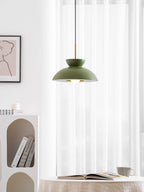 Green Clérachic pendant seen from slightly below, in front of sheer curtains and an arched white bookcase.